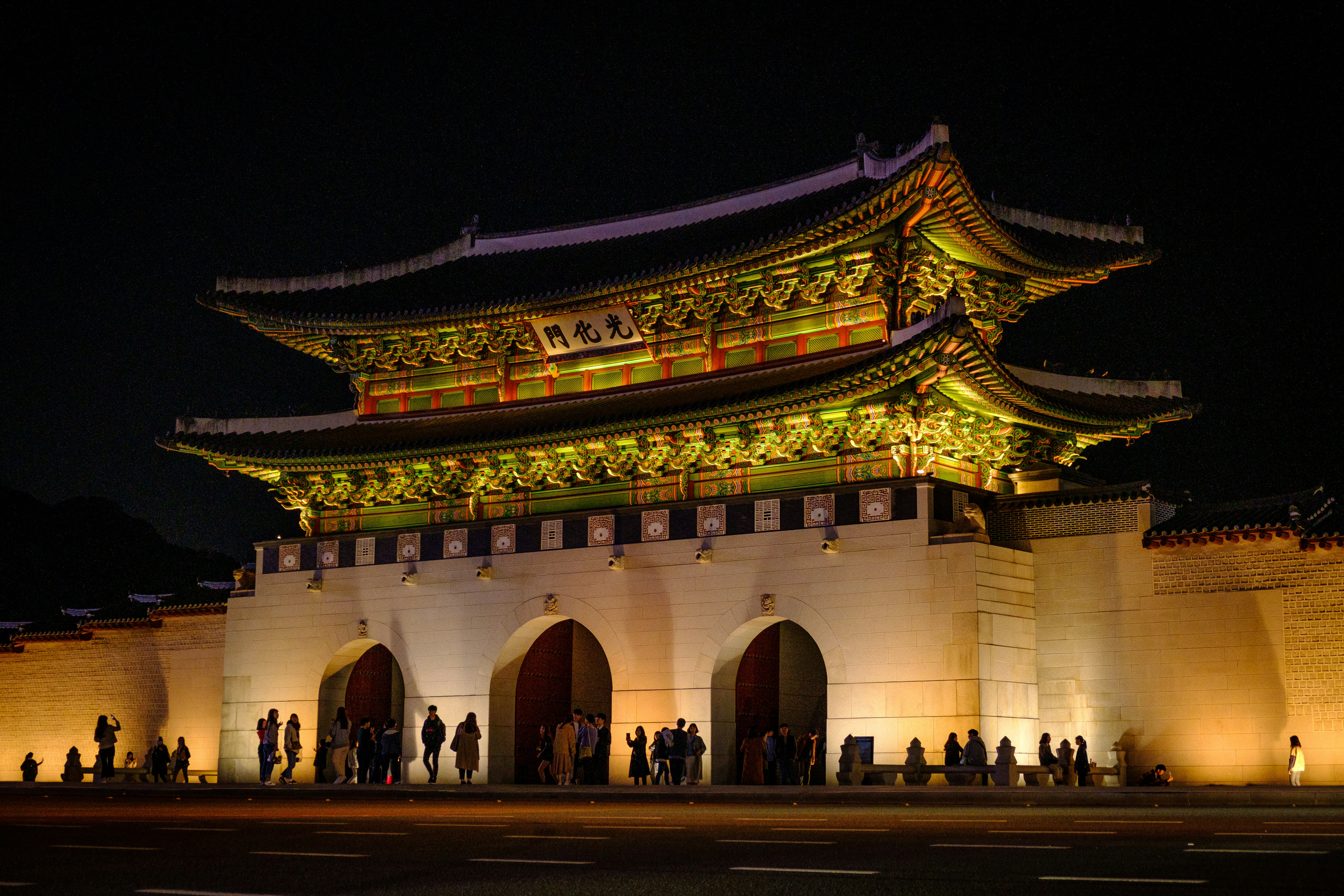 people walking near brown concrete building during nighttime